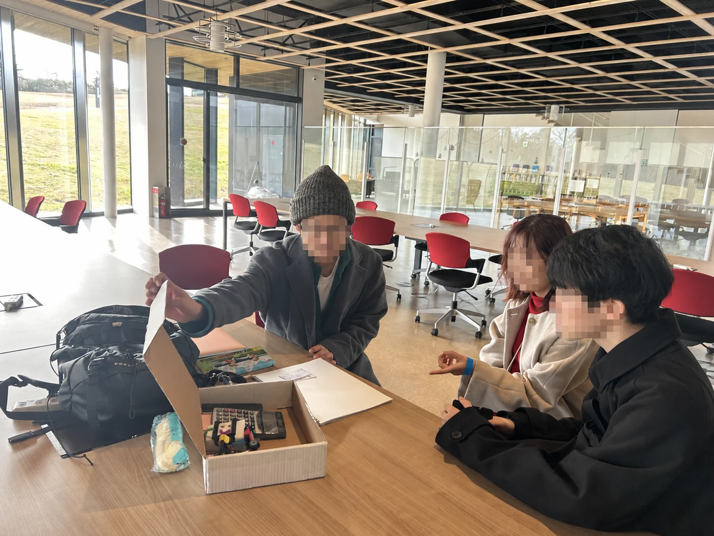 道具の入った段ボール箱を囲んで話し合う参加者